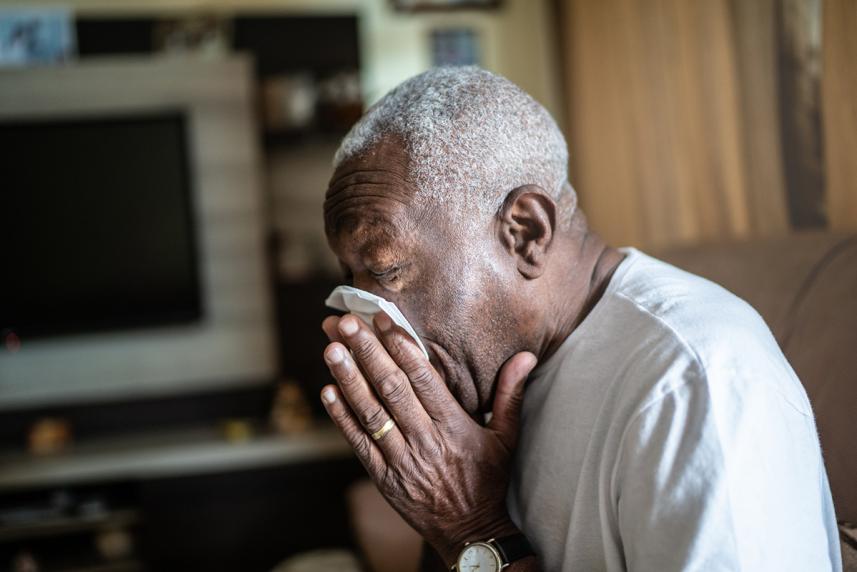 Man blowing his nose into a tissue