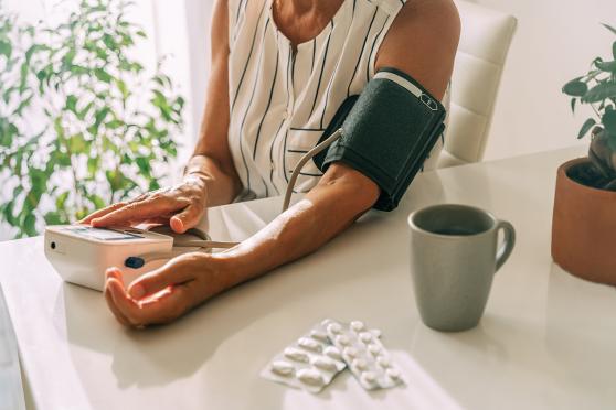 a woman is taking her blood pressure at home