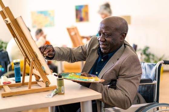 A man in a wheelchair painting